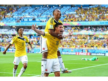 James Rodriguez of Colombia (bottom) celebrates scoring his teams third goal with Juan Camilo Zuniga (top)during the 2014 FIFA World Cup Brazil Group C match between Colombia and Greece at Estadio Mineirao on June 14, 2014 in Belo Horizonte, Brazil.