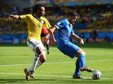 Juan Guillermo Cuadrado of Colombia and Sokratis Papastathopoulos of Greece battle for the ball during the 2014 FIFA World Cup Brazil Group C match between Colombia and Greece at Estadio Mineirao on June 14, 2014 in Belo Horizonte, Brazil.
