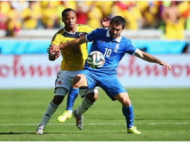 Juan Camilo Zuniga of Colombia and Giorgos Karagounis of Greece battle for the ball during the 2014 FIFA World Cup Brazil Group C match between Colombia and Greece at Estadio Mineirao on June 14, 2014 in Belo Horizonte, Brazil.