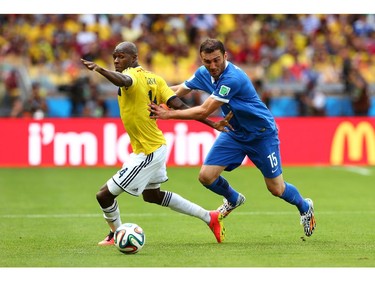 Victor Ibarbo of Colombia is challenged by Vasilis Torosidis of Greece during the 2014 FIFA World Cup Brazil Group C match between Colombia and Greece at Estadio Mineirao on June 14, 2014 in Belo Horizonte, Brazil.