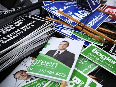 Confiscated election signs lay in a pile in the impound lot at Ottawa By-Law offices on Industrial Avenue on Wednesday, June 11, 2014.