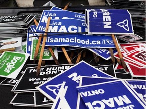 Confiscated election signs lay in a pile in the impound lot at Ottawa By-Law offices on Industrial Avenue on Wednesday.