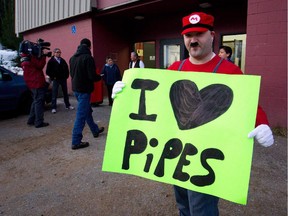 In this photo from early 2012, Danny Nunes holds a sign in support of the Enbridge Northern Gateway Project outside hearings for the project in Kitimaat Village, B.C.