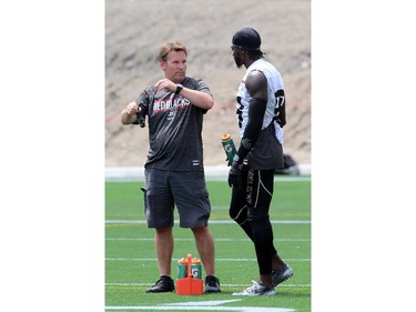 Dave Wright (L), head athletic trainer, of the Ottawa Redblacks with player Carlton Mitchell #88 during a practice at TD Place stadium in Ottawa on June 29, 2014.