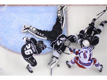 Los Angeles Kings goalie Jonathan Quick makes a save as New York Rangers right wing Derek Dorsett (15) fights for the puck during the second period of Game 5 of the NHL Stanley Cup Final series Friday, June 13, 2014, in Los Angeles.