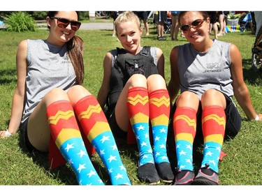 Dragon boaters Julia Ash, Amelie Chartrand and Julie Lanctot, of 180 Fitness, show off their fancy socks at the Dragon Boat Festival at Mooney's Bay on Saturday.