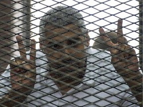 Al-Jazeera news channel's Egyptian-Canadian Mohamed Fadel Fahmy listens to the verdict inside the defendants cage during his trial for allegedly supporting the Muslim Brotherhood on June 23, 2014 at the police institute near Cairo's Tora prison.