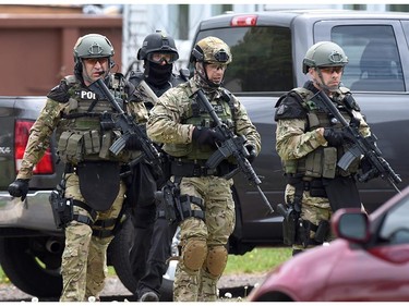 Emergency response officers check a residence in Moncton, New Brunswick, Thursday, June 5, 2014, searching for a suspect who shot and killed three Royal Canadian Mounted Police officers the day before. Wednesday. Police have identified a suspect as 24-year-old Justin Bourque of Moncton. Two other officers were wounded in Wednesday's shooting.