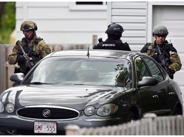 Emergency response officers check a residence in Moncton, New Brunswick, Thursday, June 5, 2014, searching for a suspect who shot and killed three Royal Canadian Mounted Police officers the day before. Wednesday. Police have identified a suspect as 24-year-old Justin Bourque of Moncton. Two other officers were wounded in Wednesday's shooting.