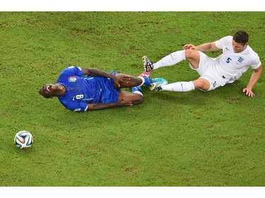 Mario Balotelli of Italy lies on the field after a tackle by Gary Cahill of England during the 2014 FIFA World Cup Brazil Group D match between England and Italy at Arena Amazonia on June 14, 2014 in Manaus, Brazil.