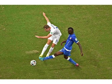 MANAUS, BRAZIL - JUNE 14:  Jordan Henderson of England and Mario Balotelli of Italy battle for the ball during the 2014 FIFA World Cup Brazil Group D match between England and Italy at Arena Amazonia on June 14, 2014 in Manaus, Brazil.