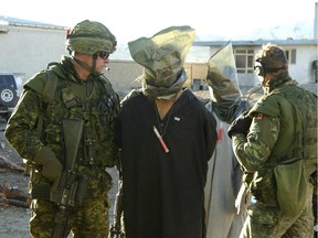 This file photo shows Canadian soldiers with Afghan detainees. Photo courtesy Canadian Forces.