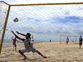 Brazilian kids play football on the beach of Cumbuco, Ceara, on June 13, 2014 during the 2014 FIFA World Cup.