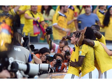 Colombia's midfielder James Rodriguez (L) celebrates with teammates after scoring during a Group C football match between Colombia and Greece at the Mineirao Arena in Belo Horizonte during the 2014 FIFA World Cup on June 14, 2014.