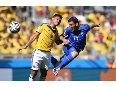 Greece's defender Vasilis Torosidis (R) vies with Colombia's forward Teofilo Gutierrez (L) during a Group C football match between Colombia and Greece at the Mineirao Arena in Belo Horizonte during the 2014 FIFA World Cup on June 14, 2014.
