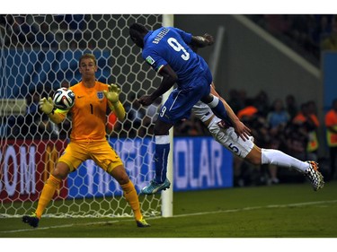 Italy's forward Mario Balotelli (C) heads the ball to score a goal as England's goalkeeper Joe Hart (L) and England's defender Gary Cahill try to defend during a Group D football match between England and Italy at the Amazonia Arena in Manaus during the 2014 FIFA World Cup on June 14, 2014.