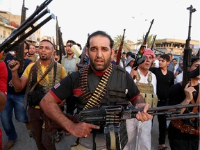 In this Friday, June 13, 2014 photo, Iraqi Shiite fighters deploy with their weapons while chanting slogans against the al-Qaida-inspired Islamic State of Iraq and the Levant,  to help the military, which defends the capital in Baghdad's Sadr City, Iraq.