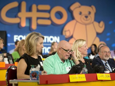 Former Mayor of Ottawa Larry O'Brien, second from left, takes to the phones during the CHEO telethon at the Ernst and Young Centre on Sunday, June 8, 2014.