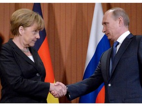 German Chancellor Angela Merkel (L) shakes hands with Russian President Vladimir Putin during a meeting at the Normandy Barriere hotel in Deauville on June 6, 2014.  The D-Day ceremonies on June 6 this year mark the 70th anniversary since the launch of 'Operation Overlord', a vast military operation by Allied forces in Normandy, which turned the tide of World War II, eventually leading to the liberation of occupied France and the end of the war against Nazi Germany.