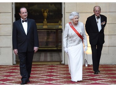 French President Francois Hollande, left, arrives with Britain's Queen Elizabeth II and husband Prince Philip for a state dinner at the Elysee presidential palace in Paris, Friday, June 6, 2014, following the international D-Day commemoration ceremonies in Normandy, marking the 70th anniversary of the World War II Allied landings in Normandy.
