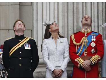 From left, Britain's Prince Harry, Kate, Duchess of Cambridge, and Prince William, watch a Royal Air Force fly past, as they appear on the balcony of Buckingham Palace, during the Trooping The Colour parade, in central London, Saturday, June 14, 2014. Hundreds of soldiers in ceremonial dress have marched in London in the annual "Trooping the Colour" parade to mark the official birthday of Queen Elizabeth II. "Trooping the Colour" originated from traditional preparations for battle, when flags were carried or "trooped" down the rank for soldiers to see.