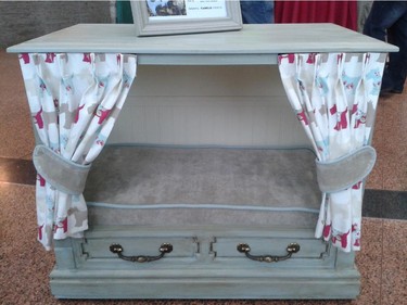A repurposed vintage TV console sees new life as a cosy dog retreat in the Homes with Woofs fundraiser for the Ottawa Humane Society June 12, 2014. Created by Vala Home Improvements, it features custom upholstery, privacy curtains and wainscoting. It was auctioned for $475.