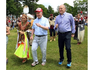 Governor General David Johnston (centre) and U.S. Ambassador Bruce Heyman dance as they take part in a powwow at the Summer Solstice Aboriginal Arts Festival in Ottawa, Saturday June 21, 2014. THE CANADIAN PRESS/Fred Chartrand