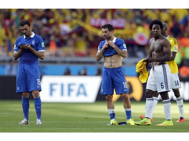 Greece's Vasilis Torosidis, left, and Greece's Giorgos Karagounis react after the group C World Cup soccer match between Colombia and Greece at the Mineirao Stadium in Belo Horizonte, Brazil, Saturday, June 14, 2014.  Colombia won the match 3-0.