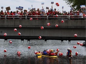 Hundreds of people gathered to protest the Enerdu hydro power project, saying it will ruin tourism, heritage flavour and the natural environment along the river and in the town of Almonte, Ont., on June 28, 2014.