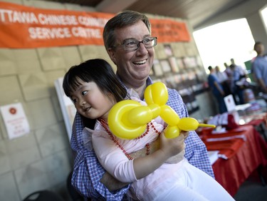 Mayor Jim Watson hugs Bunnie Shen (2) at the annual Community Welcome Fair for Immigrants and Newcomers, organized by the Ottawa Chinese Community Service Centre (OCCSC) on Sunday, June 1, 2014.