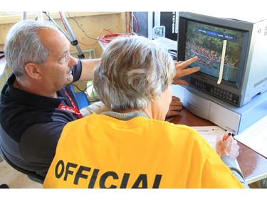 In the control tower, officials use video replay to determine racers' finishing time to the 100th of a second, at the Dragon Boat Festival at Mooney's Bay on Saturday.