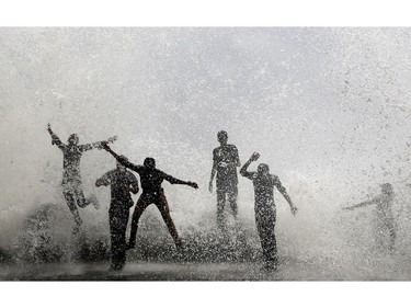 Indians enjoy high tide waves on the Arabian Sea coast in Mumbai, India, Friday, June 13, 2014. According to local reports, the city would witness high tides measuring 4.5 meters (15 feet) till Wednesday.