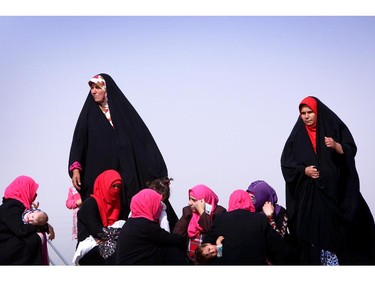 Iraqi women gather at a temporary camp set up to shelter civilians fleeing violence in Iraq's northern Nineveh province in Aski kalak, 40 kms west of the region's capital Arbil, on June 13, 2014. Thousands of people who fled Iraq's second city of Mosul after it was overrun by jihadists have been queuing in the blistering heat, hoping to enter the safety of the nearby autonomous Kurdish region and furious at Baghdad's failure to help them.