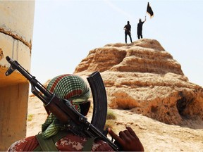 An image downloaded on June 11, 2014 from the jihadist website Welayat Salahuddin shows militants of the Islamic State of Iraq and the Levant (ISIL) waving the trademark Islamists flag after they allegedly seized an Iraqi army checkpoint in the northern Iraqi province of Salahuddin.