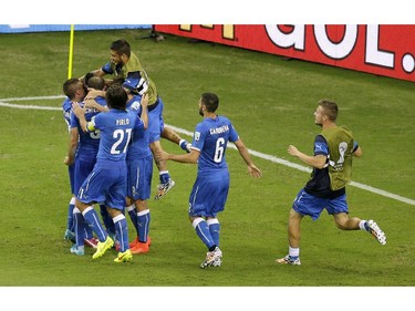 Italy players celebrate after Italy's Mario Balotelli scored his side's 2nd goal during the group D World Cup soccer match between England and Italy at the Arena da Amazonia in Manaus, Brazil, Saturday, June 14, 2014.