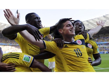 Colombia's James Rodriguez (10) celebrates with his teammates after scoring his side's third goal during the group C World Cup soccer match between Colombia and Greece at the Mineirao Stadium in Belo Horizonte, Brazil, Saturday, June 14, 2014. Colombia defeated Greece 3-0.