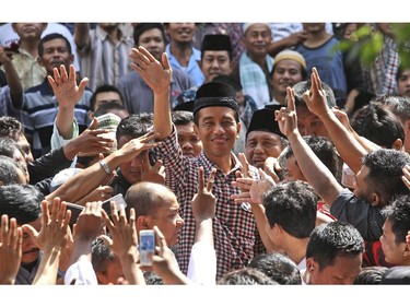 Indonesian presidential candidate Joko Widodo, popularly known as 'Jokowi,' waves at his supporters during a campaign rally in Cilacap, Central Java, Indonesia, Friday, June 13, 2014. Indonesia will hold its presidential poll on July 9.