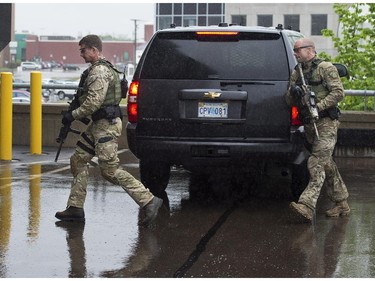 Heavily armed policemen escort Justin Bourque, the suspect in one of the worst mass shootings in the RCMP's history, as he arrives at court in Moncton, N.B. on Friday, June 6, 2014. Three RCMP officers were killed and two injured in the in shooting spree.