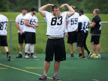Lineman Jon Gott stretches on Friday, June 13, 2014 as the Ottawa RedBlacks take to Keith Harris Field at Carleton University for a quick walk through of their assignments before they head to Saskatchewan for their first preseason game Saturday.