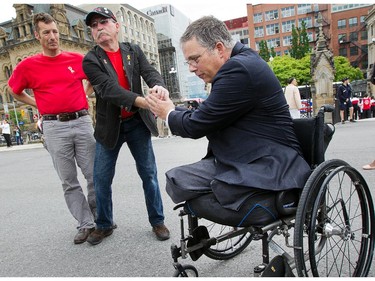 Major Mark Campbell (Ret'd) (R) who lost his legs to an IED in Afghanistan is greeted by supporters including Ken Anson (L) as 'Rock the Hill' takes place on Parliament Hill with veterans, families and supporters hoping to draw attention to the problems Canadian veterans are facing. Photo taken at 14:24 on June 4, 2014.