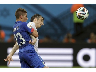 Italy's Marco Verratti, left, battles for the ball with England's Leighton Baines during the group D World Cup soccer match between England and Italy at the Arena da Amazonia in Manaus, Brazil, Saturday, June 14, 2014.