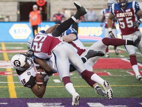 Montreal Aloutttes' Marc-Olivier Brouillette, right, and, Ed Gainey (29) tackle Ottawa Redblacks' Marcus Henry during first half CFL action in Montrea.