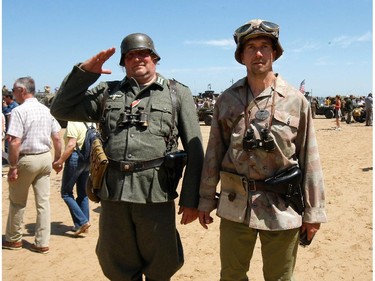 Military reenactors walk on the beach of Arromanches, France,  Friday, June 6, 2014, as part of D-Day commemorations. World leaders and veterans gathered by the beaches of Normandy on Friday to mark the 70th anniversary of World War Two's D-Day landings.