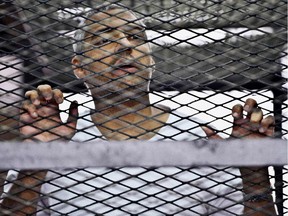 In this Thursday, May 5, 2014 photo, Mohamed Fahmy, Canadian-Egyptian acting bureau chief of Al-Jazeera, appears in a defendant's cage at a courtroom in Cairo, Egypt.