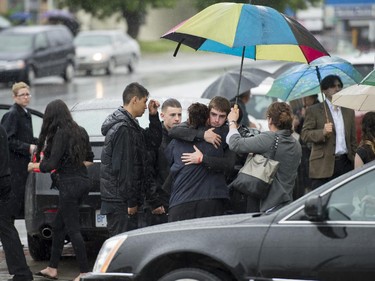 Mourners embrace outside St. Anthony's Church in Ottawa following the funeral of Brandon Volpi on Friday, June 13, 2014. Volpi, a student at St. Patrick's High School was killed in a stabbing during his prom night in downtown Ottawa.