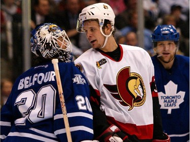 Jason Spezza of the Ottawa Senators and Ed Belfour exchange a few words as Chad Kilger of the Toronto Maple Leafs looks on during first period action of the fifth game of the Eastern Conference Quarterfinal held at the Air Canada Centre in Toronto, Friday, April 16, 2004.
