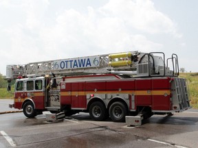 OTTAWA, ON: JULY 17, 2012 -- Firefighters were called to quell a grass fire (background) near Hurdman Station in Ottawa on Tuesday, July 17, 2012. The dry weather conditions are taxing the fire department, especially since there have been many fires far from hydrants and water. (photo by Mike Carroccetto / The Ottawa Citizen) (for CITY story by KAREN CHEN) NEG# 109678