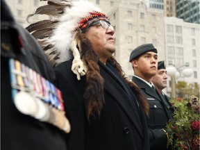 Elder Bernard Nelson (left) stands with young military cadet, Desmond Simon (centre), at a 2013 ceremony at the National Aboriginal Veterans Association Monument on Elgin Street to commemorate Aboriginal contributions to Canada's war efforts over the years. The military is struggling to recruit more Aboriginal Canadians.