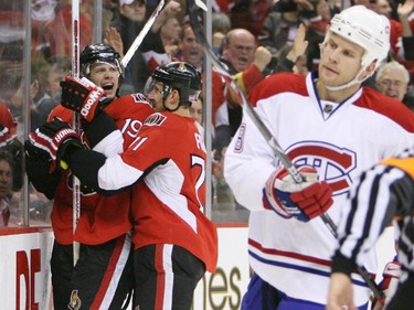 Jason Spezza and Nick Foligno of the Ottawa Senators celebrate Spezza's game winning goal against the Montreal Canadiens as Michael Komisarek of the Montreal Canadiens skates by dejected during third period action at Scotiabank Place in Ottawa, Thursday, October 18, 2007.