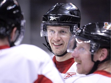 Dany Heatley (L) tells a story as Jason Spezza (C) and Daniel Alfredsson listen during the Ottawa Senators practice at Scotiabank Place.